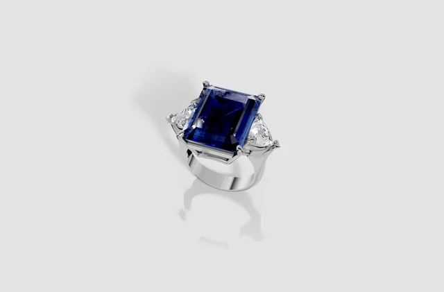 Rendering di anello con pietra centrale blu rettangolare e pietre laterali